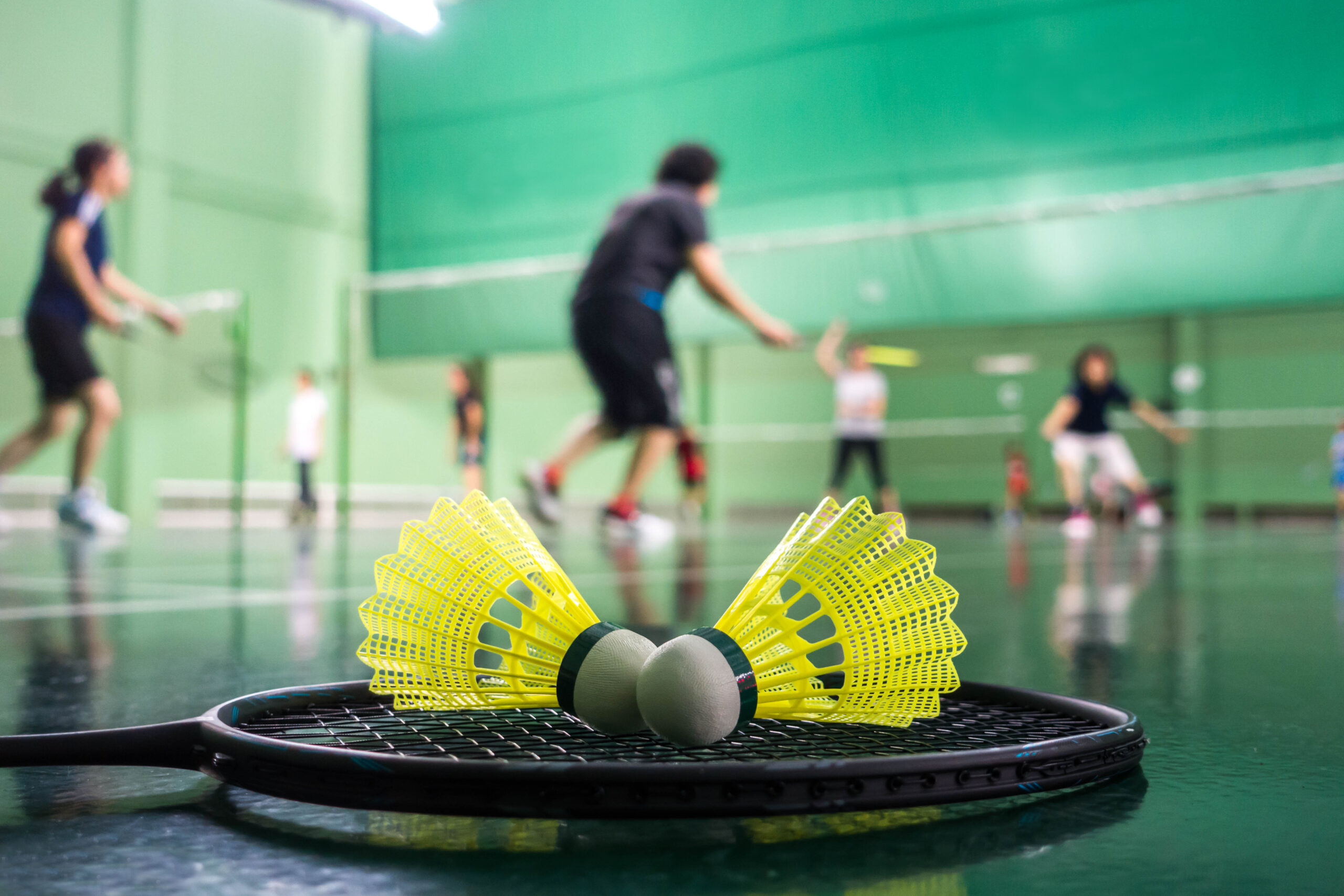 Joueurs en plein échange sur le terrain de badminton à Saint-Priest